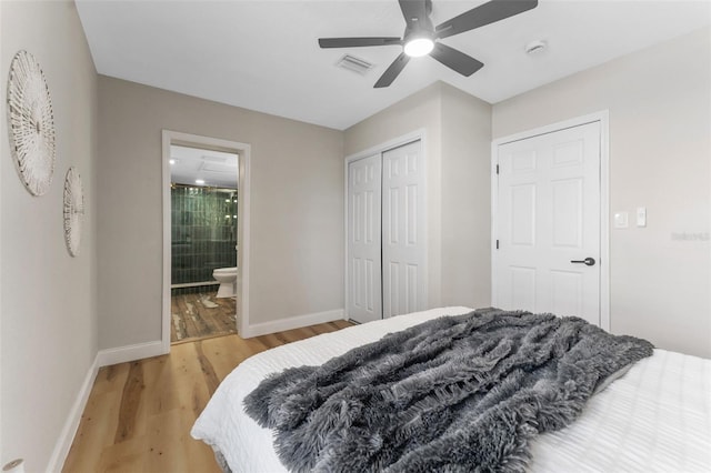 bedroom with light wood-type flooring, visible vents, a closet, connected bathroom, and baseboards