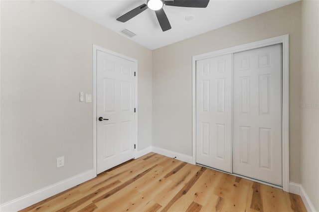 unfurnished bedroom featuring light wood finished floors, visible vents, a closet, and baseboards