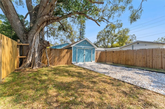 view of yard featuring an outbuilding, a storage shed, and a fenced backyard