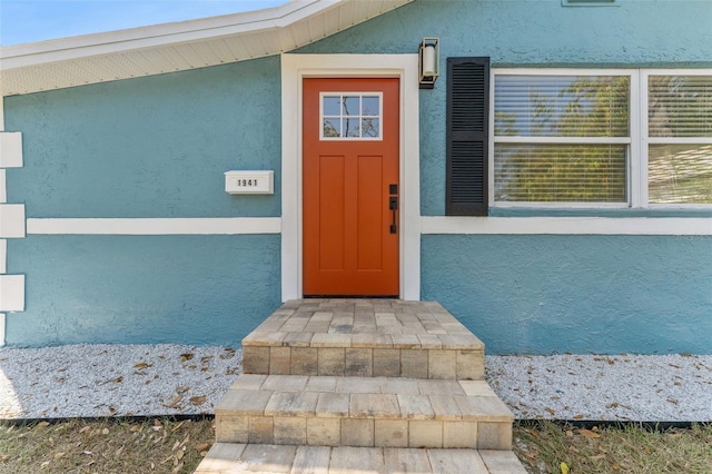 entrance to property featuring stucco siding