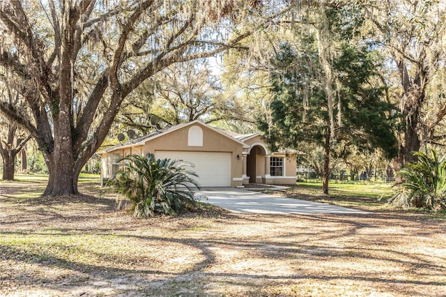 view of front of home featuring stucco siding, a garage, and driveway