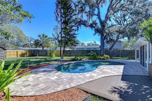 view of swimming pool featuring a yard, a fenced in pool, a fenced backyard, and a patio area