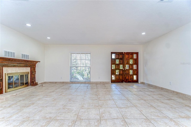 unfurnished living room featuring light tile patterned floors, visible vents, a fireplace, and baseboards