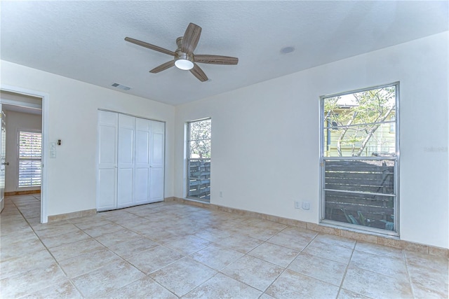 unfurnished bedroom with visible vents, multiple windows, and a textured ceiling