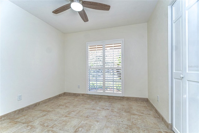 spare room featuring baseboards and ceiling fan