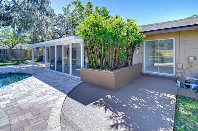 view of patio / terrace with a fenced in pool, fence, and a sunroom