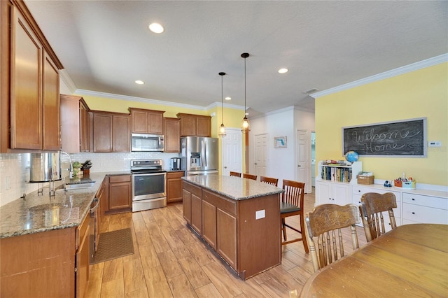 kitchen with stone countertops, a center island, stainless steel appliances, light wood finished floors, and decorative backsplash