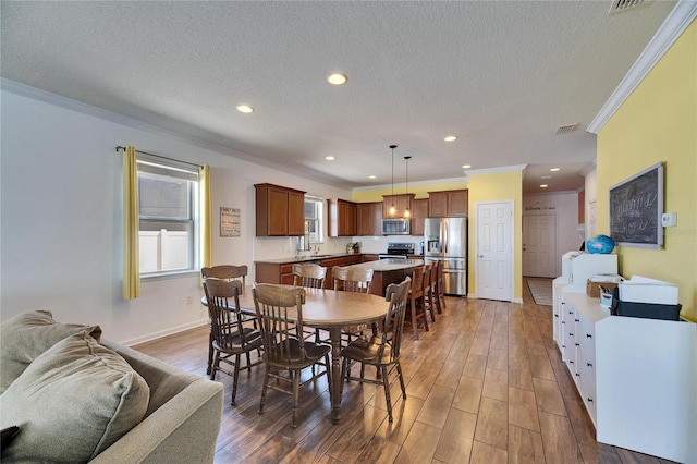 dining area with recessed lighting, wood finished floors, visible vents, and a textured ceiling