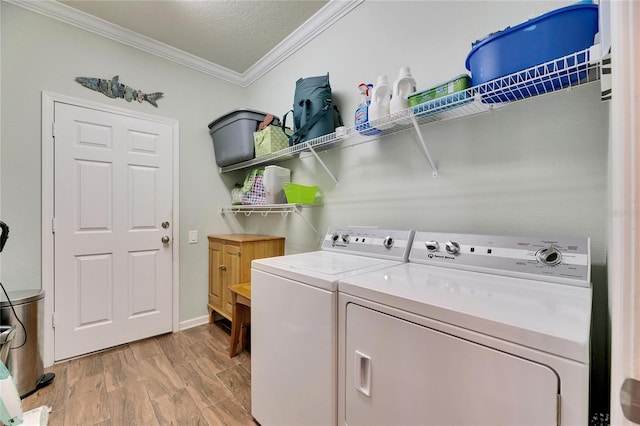 laundry area with light wood finished floors, crown molding, laundry area, washer and dryer, and a textured ceiling