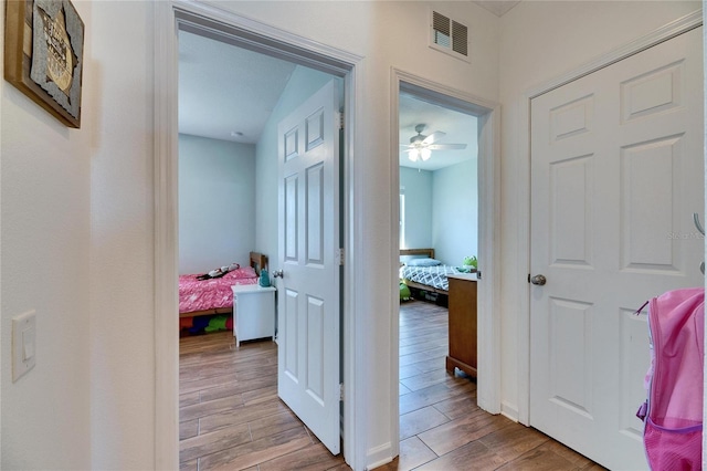 hallway with visible vents and wood tiled floor