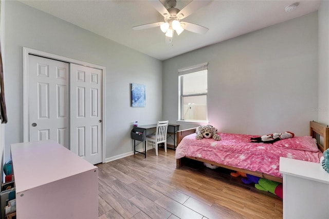 bedroom featuring light wood-type flooring, baseboards, a closet, and a ceiling fan