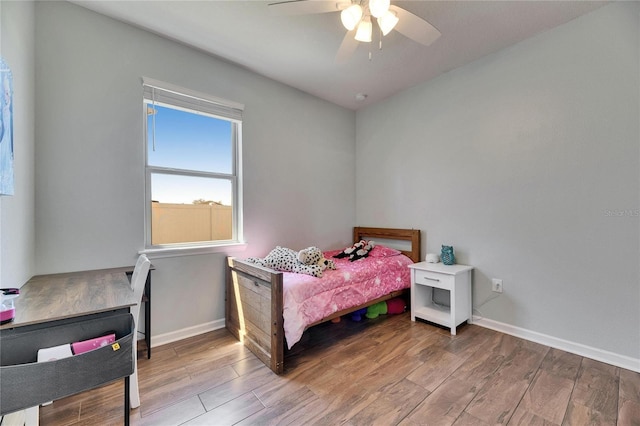 bedroom featuring a ceiling fan, baseboards, and wood finished floors