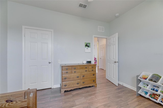 bedroom with visible vents, baseboards, and wood tiled floor