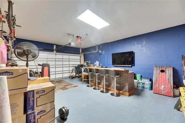 garage with concrete block wall and a garage door opener