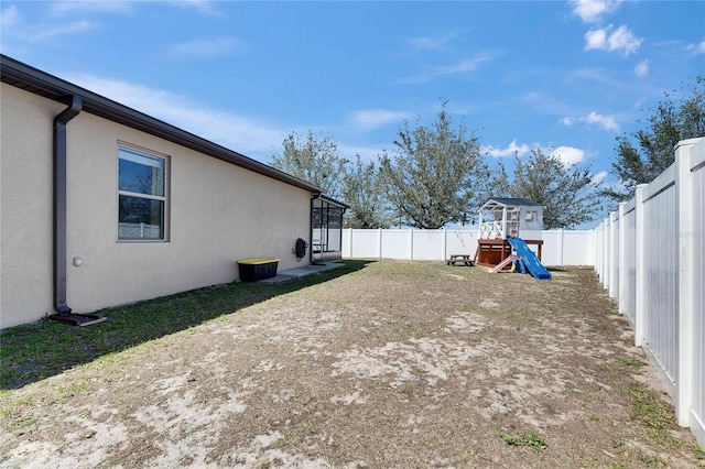 view of yard featuring a playground and a fenced backyard