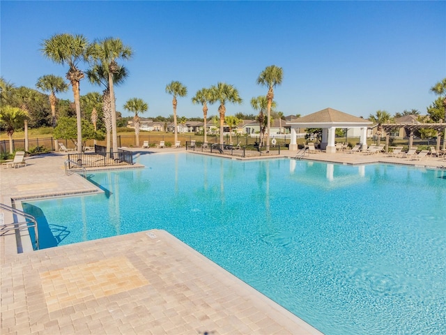 community pool featuring a gazebo, fence, and a patio area