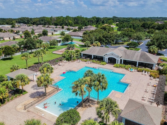 community pool with a patio area and fence