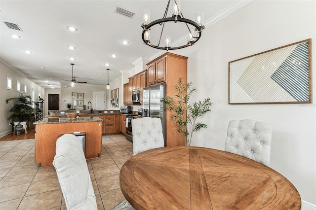 dining room with light tile patterned floors, visible vents, and ornamental molding