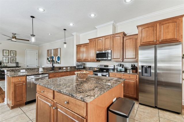 kitchen with a sink, a kitchen island, stainless steel appliances, a peninsula, and light tile patterned floors