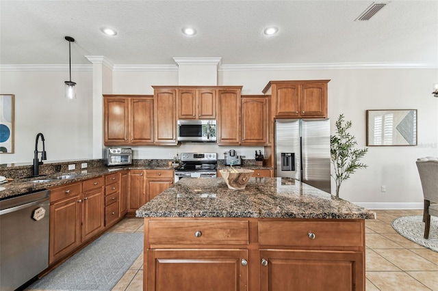 kitchen with visible vents, a sink, dark stone countertops, appliances with stainless steel finishes, and light tile patterned flooring