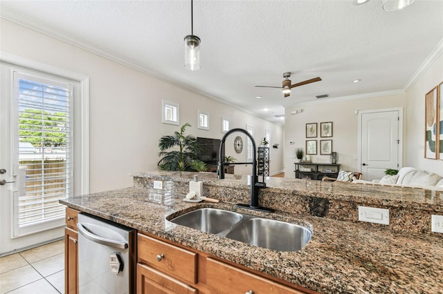 kitchen with a sink, open floor plan, dark stone counters, brown cabinetry, and crown molding