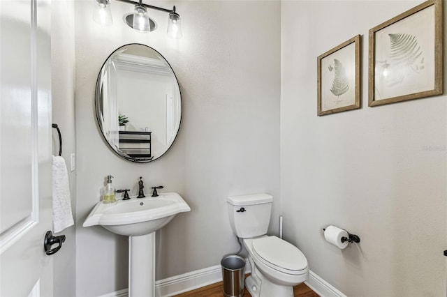 bathroom with toilet and baseboards