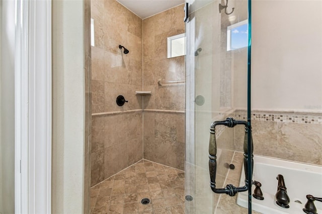 bathroom with a bath and a stall shower