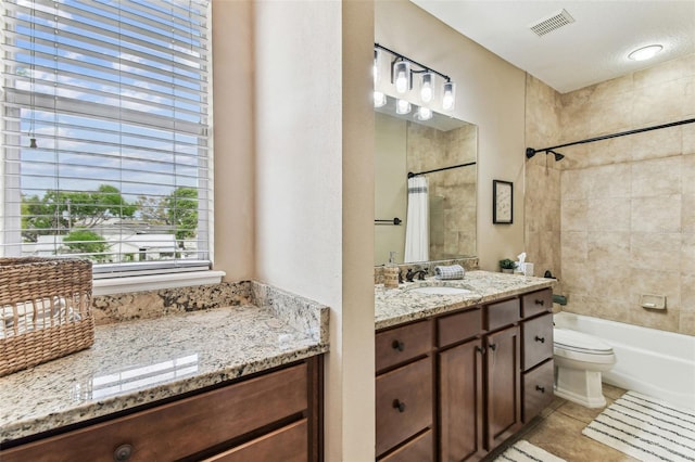 bathroom with vanity, shower / bathtub combination with curtain, visible vents, tile patterned floors, and toilet