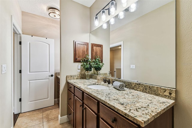 bathroom featuring vanity, tile patterned floors, and baseboards