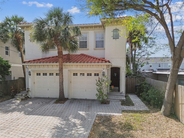 view of front facade with decorative driveway, fence, and stucco siding