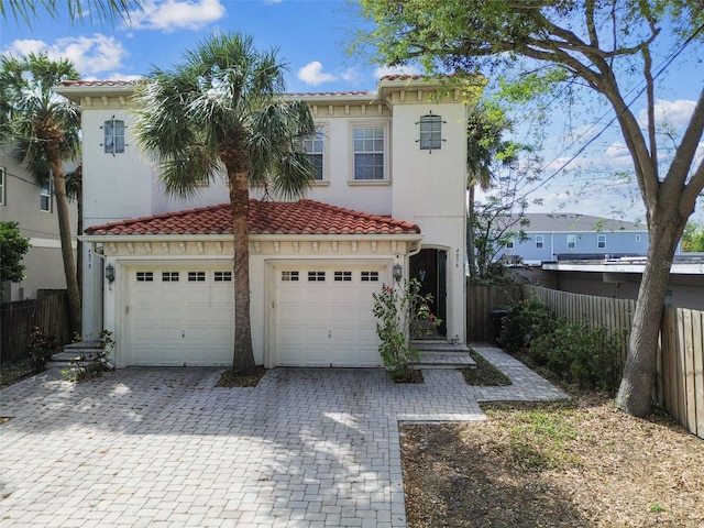 view of front of home with stucco siding, decorative driveway, fence, an attached garage, and a tiled roof