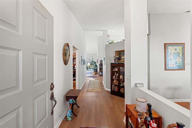 hallway with wood finished floors and baseboards