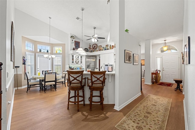 kitchen featuring visible vents, stainless steel built in refrigerator, a peninsula, light wood-style floors, and white cabinets