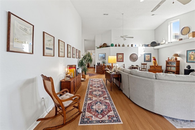 living area with light wood-type flooring, baseboards, visible vents, and a ceiling fan