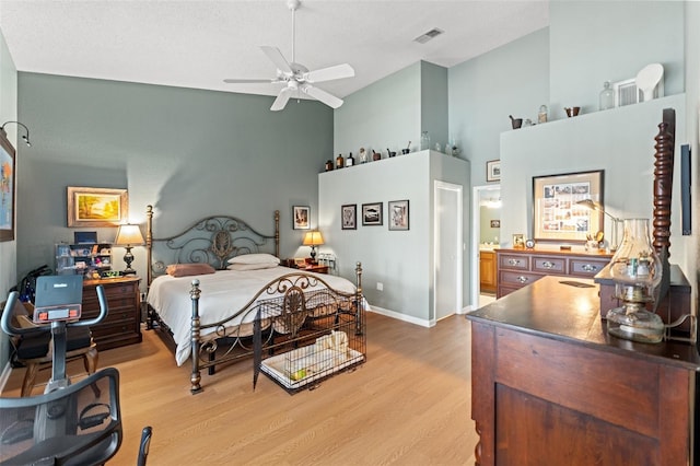 bedroom featuring visible vents, ceiling fan, baseboards, light wood-style floors, and high vaulted ceiling