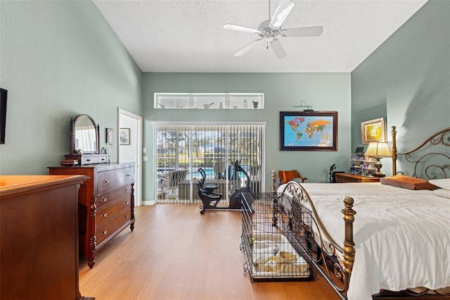 bedroom with a textured ceiling, wood finished floors, a ceiling fan, and access to outside