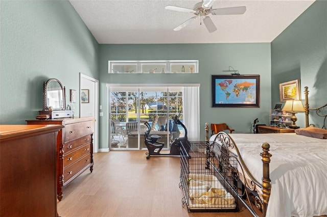 bedroom with a textured ceiling, wood finished floors, ceiling fan, and access to outside