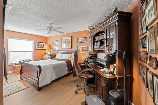 bedroom with visible vents, a textured ceiling, and light wood-style floors