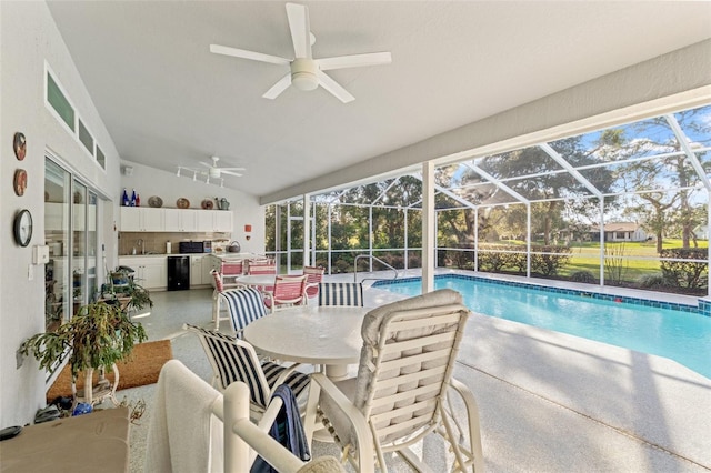 outdoor pool featuring a patio, an outdoor kitchen, ceiling fan, a sink, and a lanai