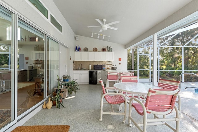 sunroom with vaulted ceiling, plenty of natural light, a ceiling fan, and a sink