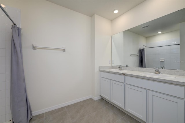 full bath featuring tile patterned floors, visible vents, double vanity, and a sink