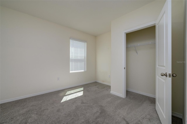 unfurnished bedroom featuring carpet flooring, baseboards, and a closet