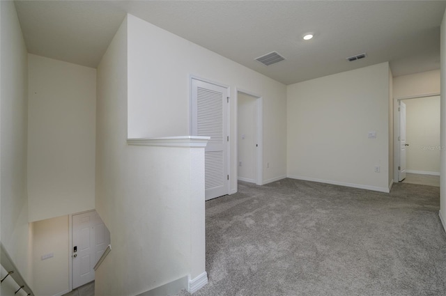 unfurnished room with visible vents, baseboards, and carpet floors