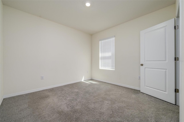 carpeted spare room with baseboards