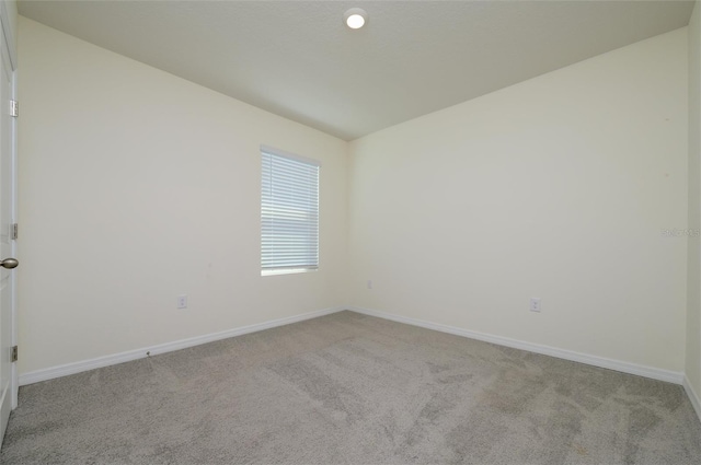 carpeted spare room featuring baseboards