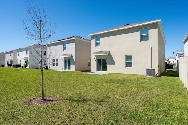 rear view of property with central air condition unit, stucco siding, a yard, and fence