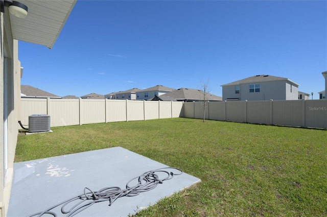 view of yard featuring central air condition unit, a patio, a residential view, and a fenced backyard