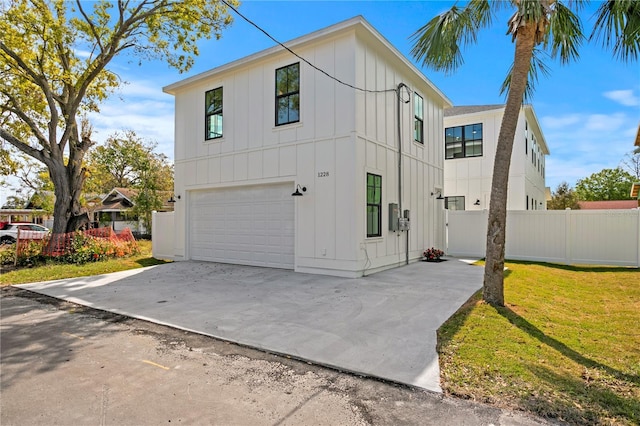 view of front of property with a garage, board and batten siding, concrete driveway, and fence