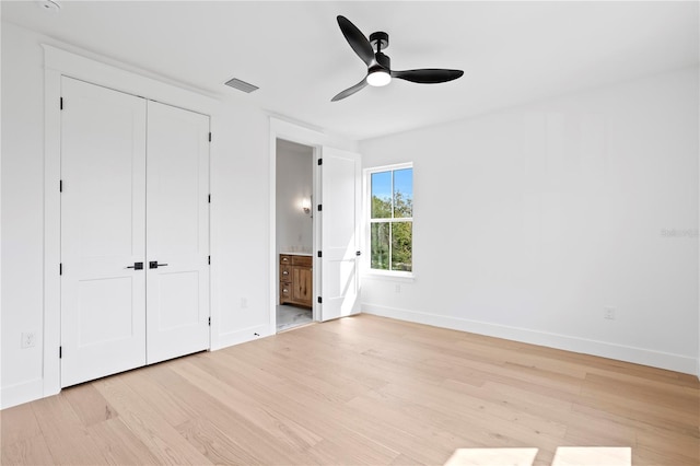 unfurnished bedroom with visible vents, baseboards, ensuite bath, and light wood-style flooring