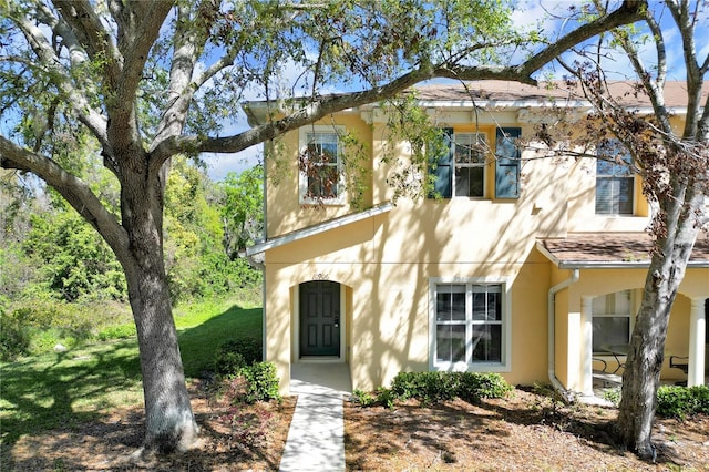 view of front of house featuring stucco siding and a front lawn